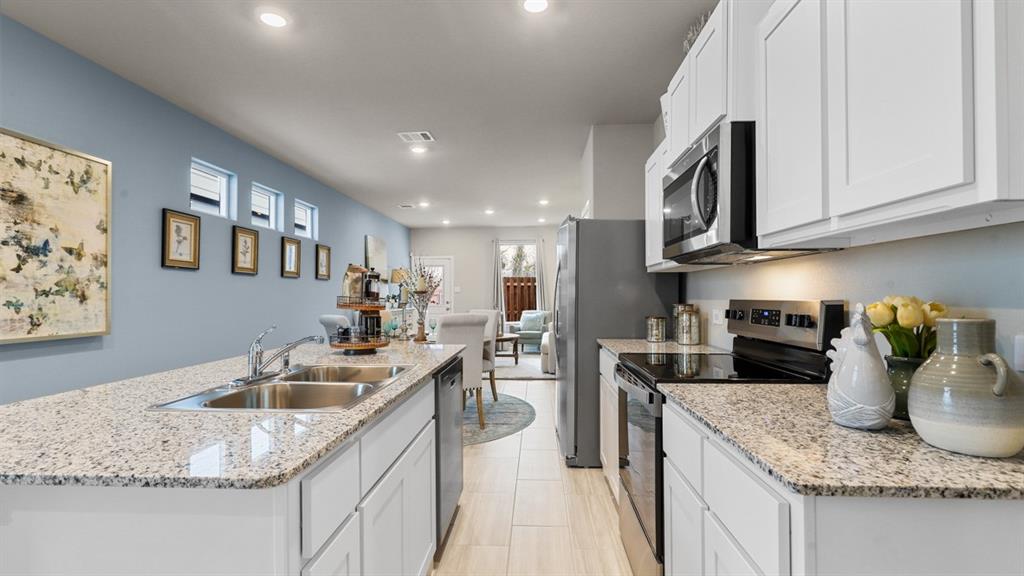 3053 Maple Orch Lane Fort Worth, TX 76140 - Photo 3 of 38 a kitchen with kitchen island granite countertop a sink stainless steel appliances and cabinets