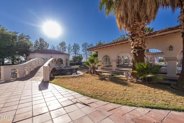 a view of a livingroom with a fireplace a ceiling fan and windows