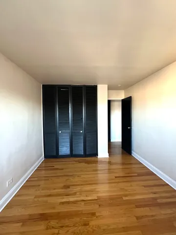 a view of an empty room with closet and entryway