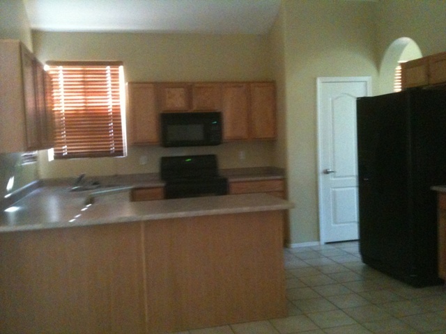 3235 West Maldonado Road Phoenix, AZ 85041 - Photo 6 of 17 a kitchen with stainless steel appliances a sink and a refrigerator