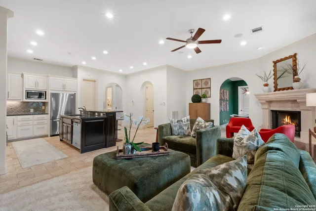 a living room with fireplace furniture and a view of kitchen