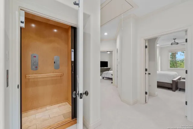 a bedroom with a large bed and a chandelier