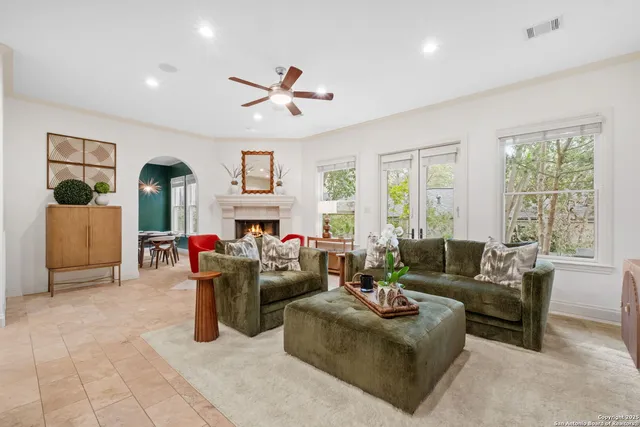 a living room with fireplace furniture and a large window
