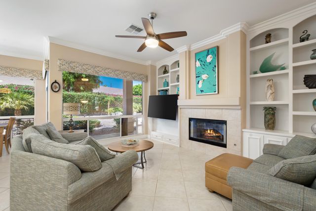 a living room with furniture fireplace and a large window