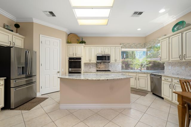 a large kitchen with stainless steel appliances cabinets a sink and a counter top space