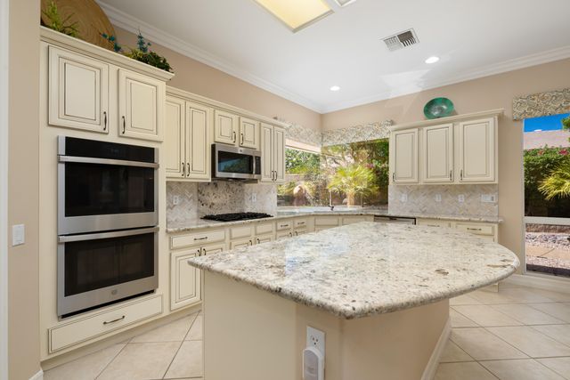 a kitchen with granite countertop cabinets stainless steel appliances and a counter space