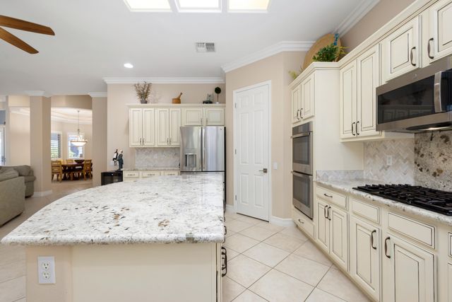 a kitchen with stainless steel appliances granite countertop a stove a sink and a refrigerator