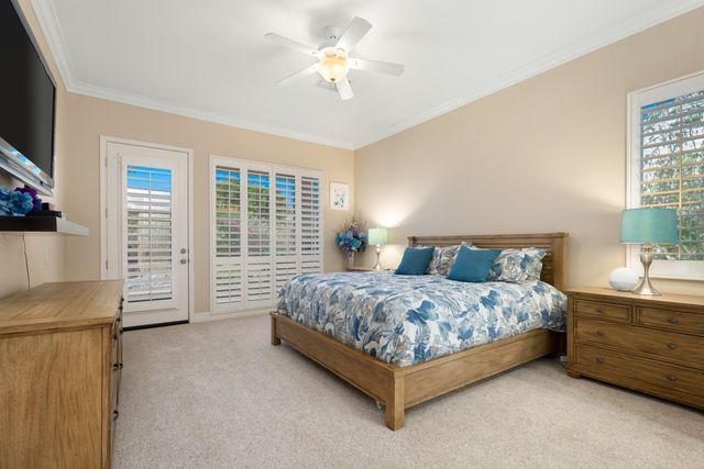 a bedroom with a bed chandelier and a window