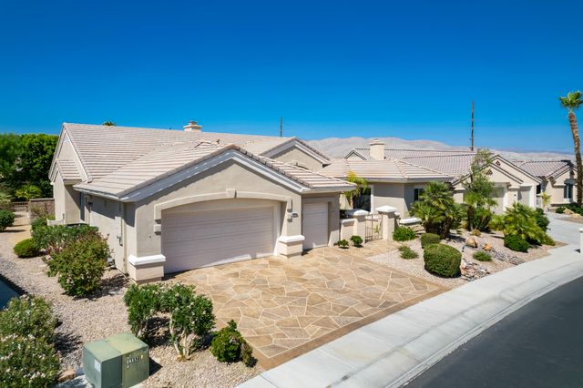a view of a patio with table and chairs potted plants and palm tree