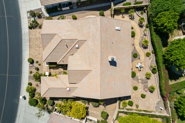 an aerial view of a white house with a yard and potted plants