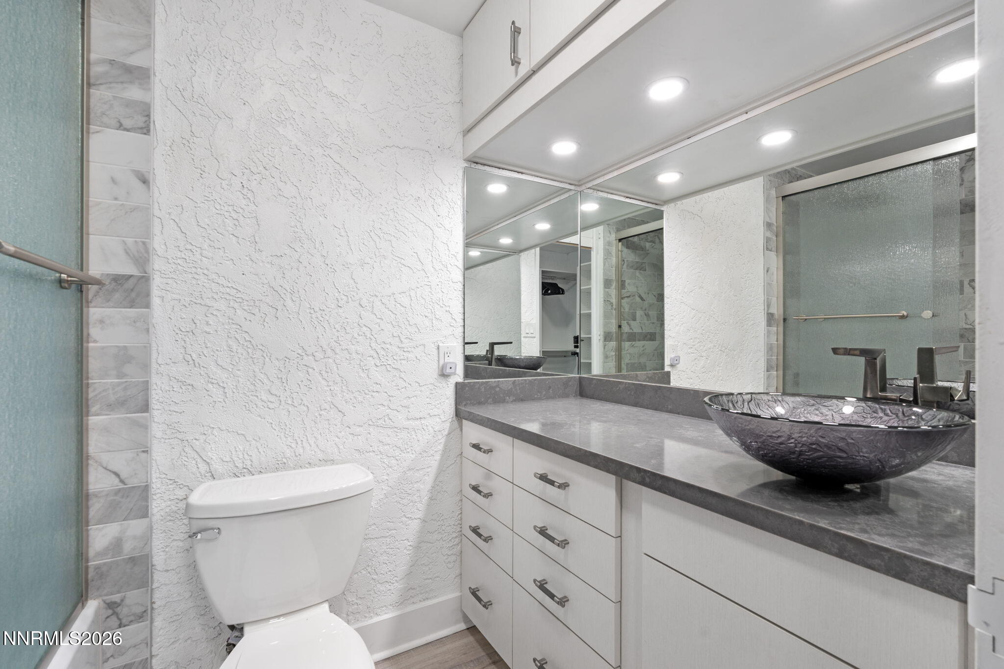 100 North Arlington Avenue, Unit 22G Reno, NV 89501 - Photo 12 of 37 a bathroom with a granite countertop sink mirror and toilet