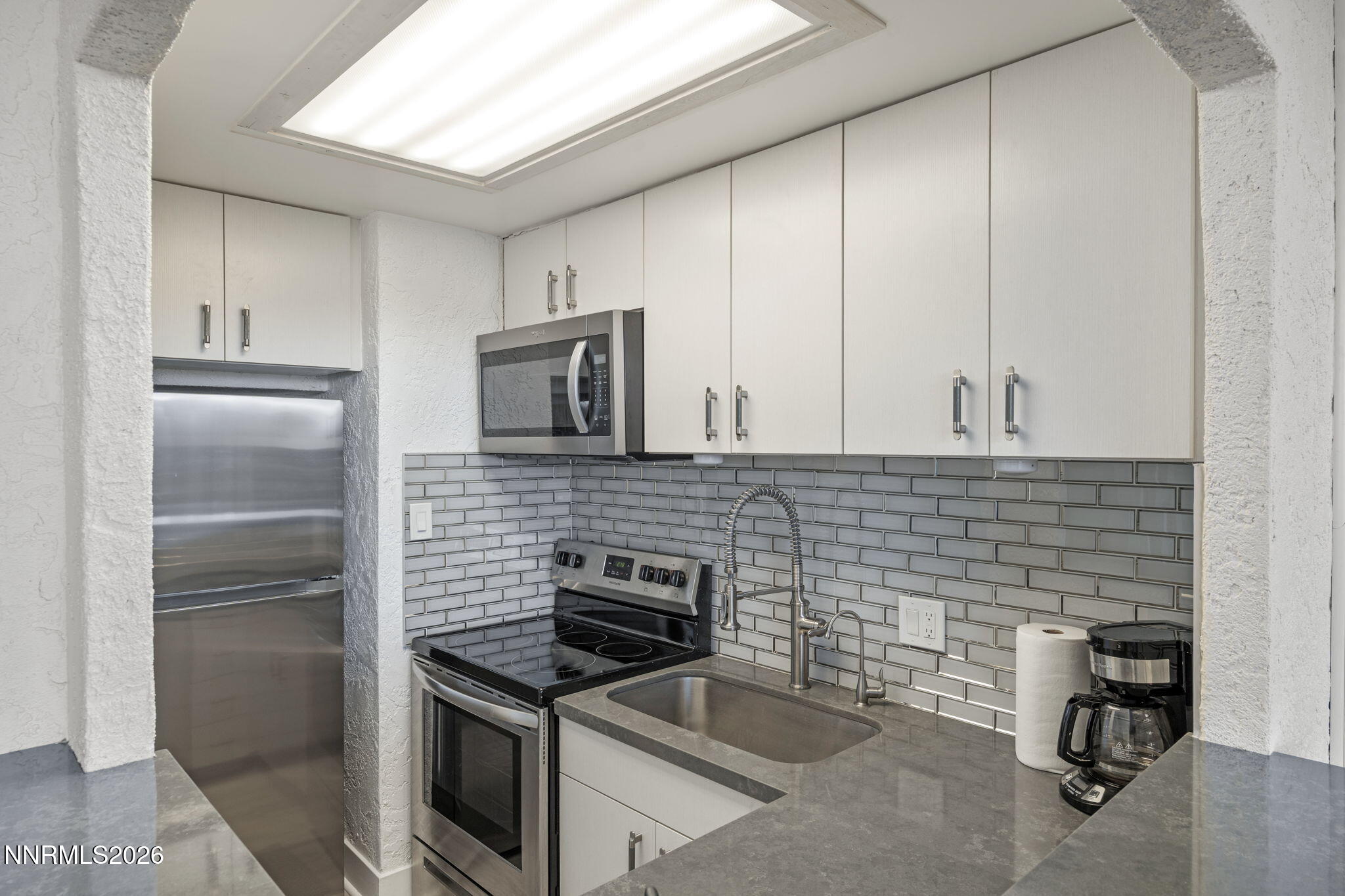100 North Arlington Avenue, Unit 22G Reno, NV 89501 - Photo 26 of 37 a kitchen with a refrigerator stove and cabinets