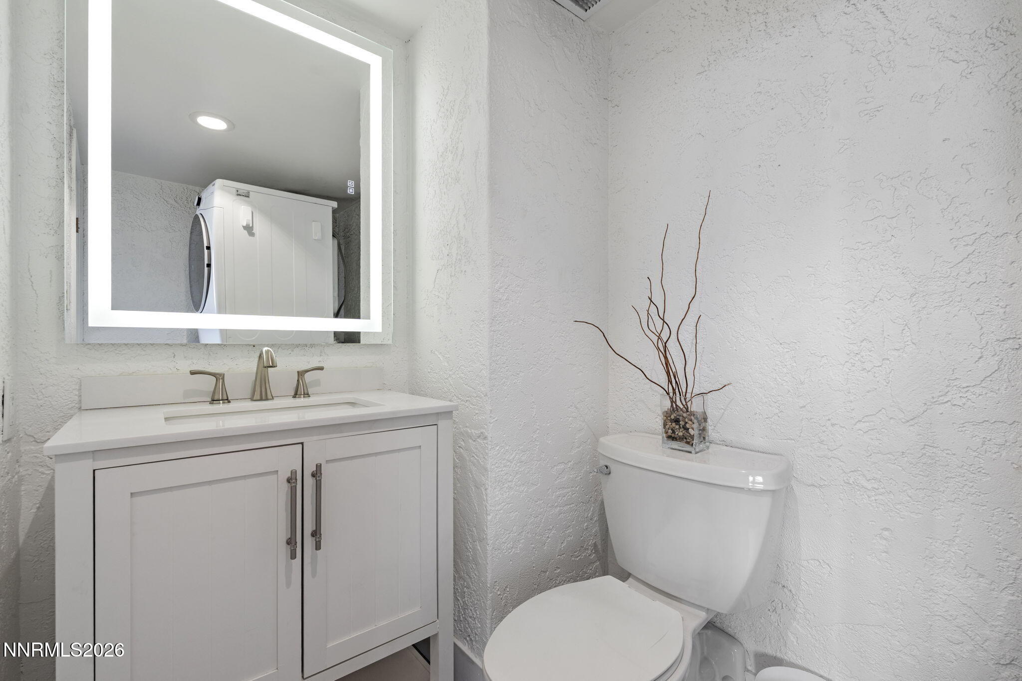 100 North Arlington Avenue, Unit 22G Reno, NV 89501 - Photo 28 of 37 a bathroom with a toilet a sink and mirror