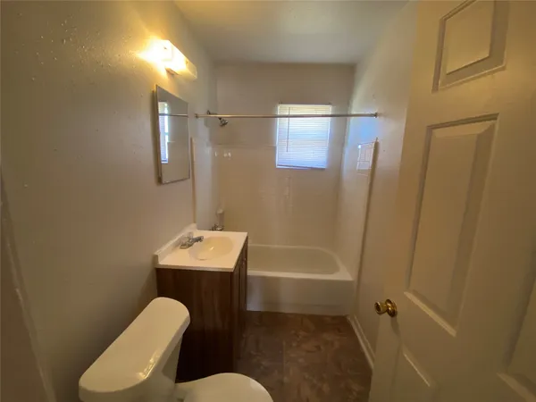 a bathroom with sink mirror bathtub and toilet