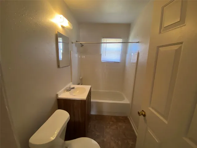 a bathroom with sink mirror bathtub and toilet