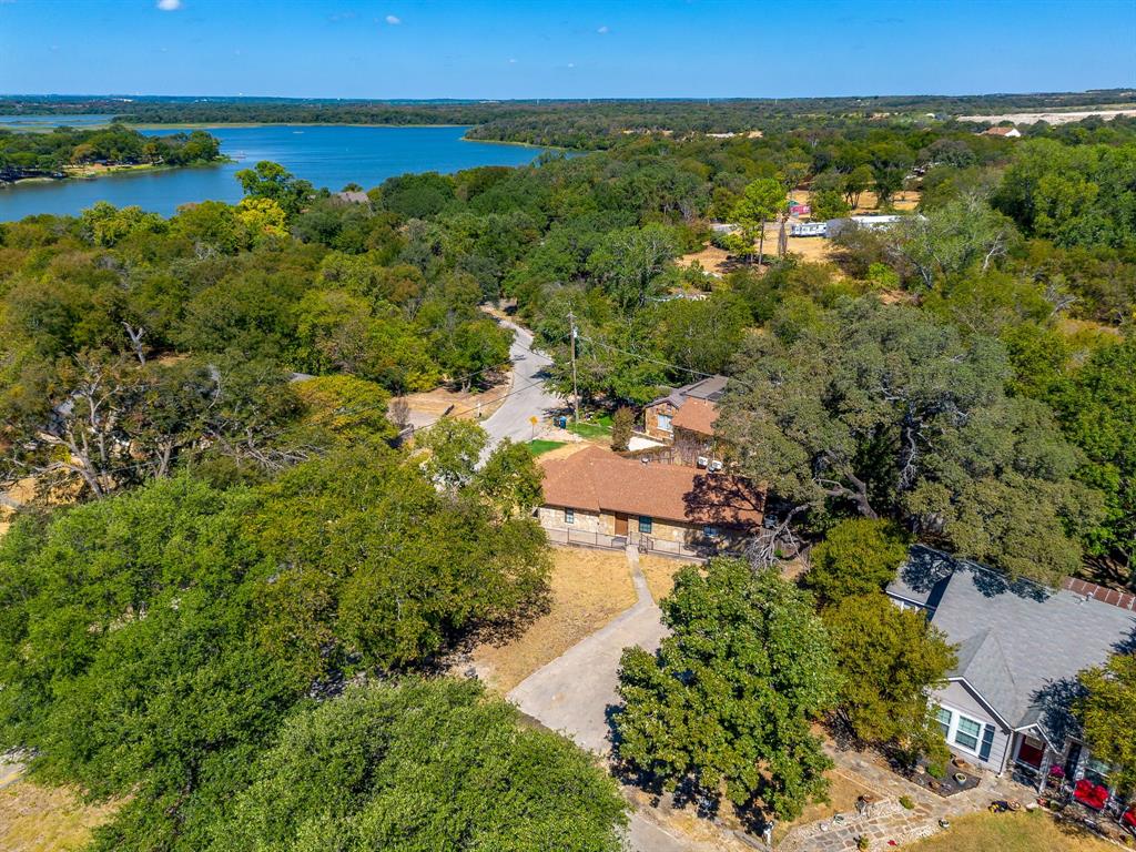 6940 Hatch Road Fort Worth, TX 76135 - Photo 2 of 40 Aerial establishing shot with lake, mature trees, and residential architecture