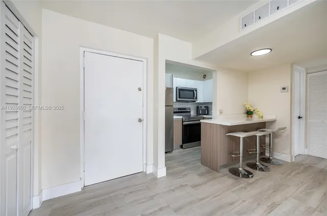 a view of kitchen with sink refrigerator dining table and chair