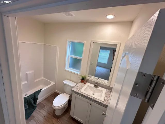 a bathroom with a granite countertop toilet sink and mirror