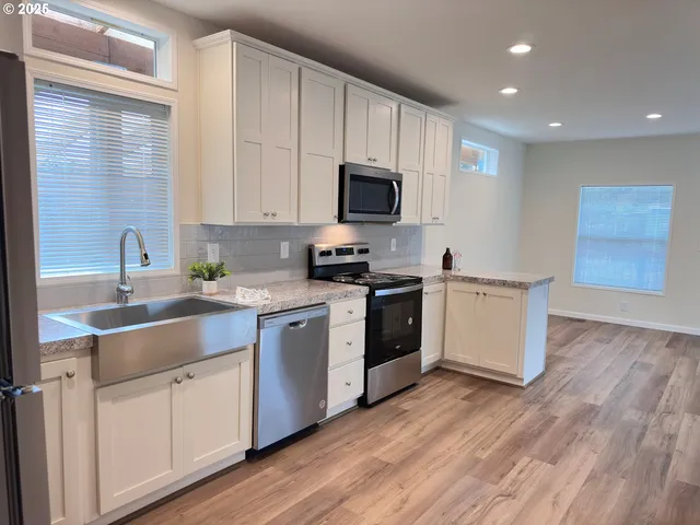 a kitchen with sink a microwave and cabinets