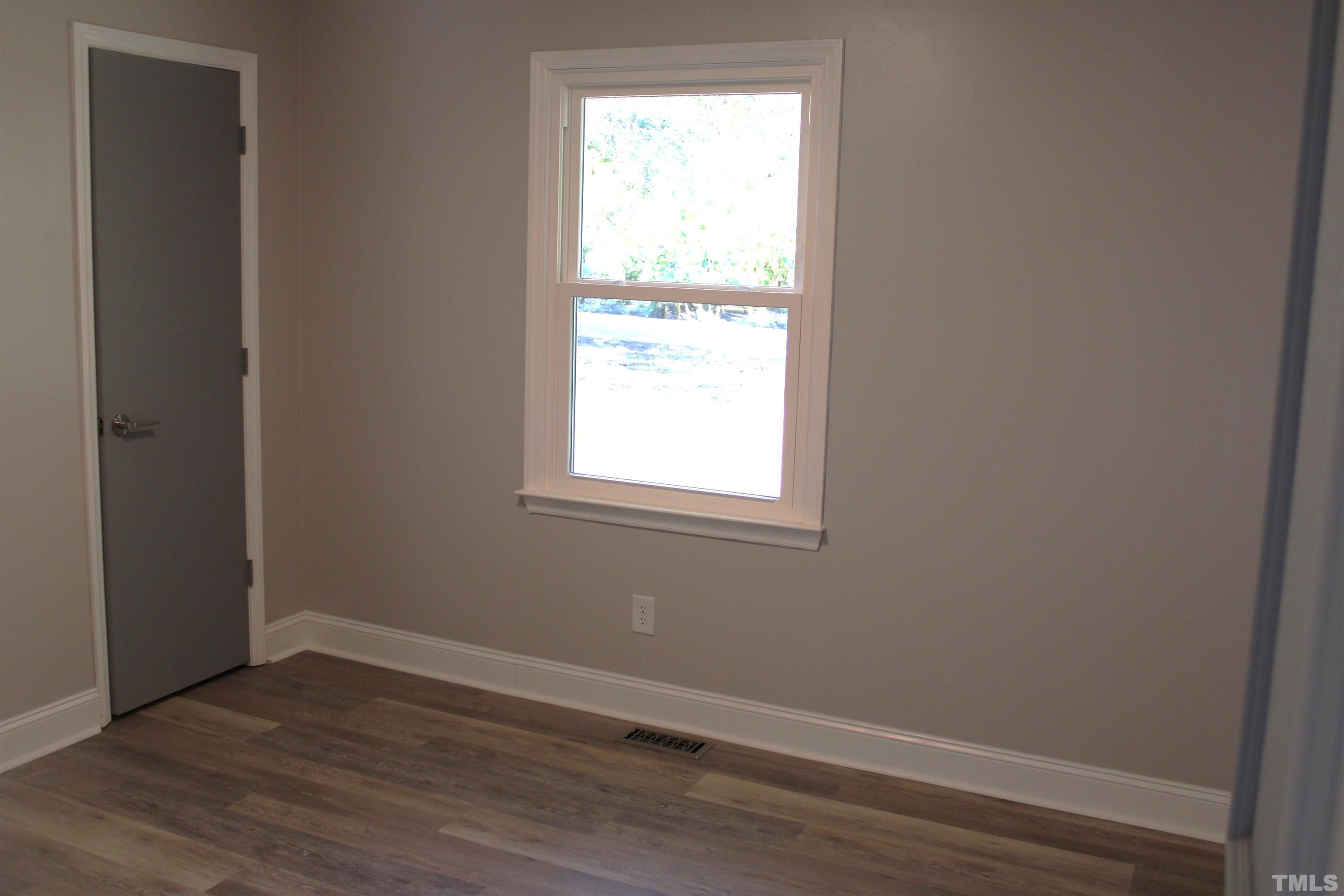 9300 Sauls Road Raleigh, NC 27603 - Photo 13 of 17 an empty room with wooden floor and windows