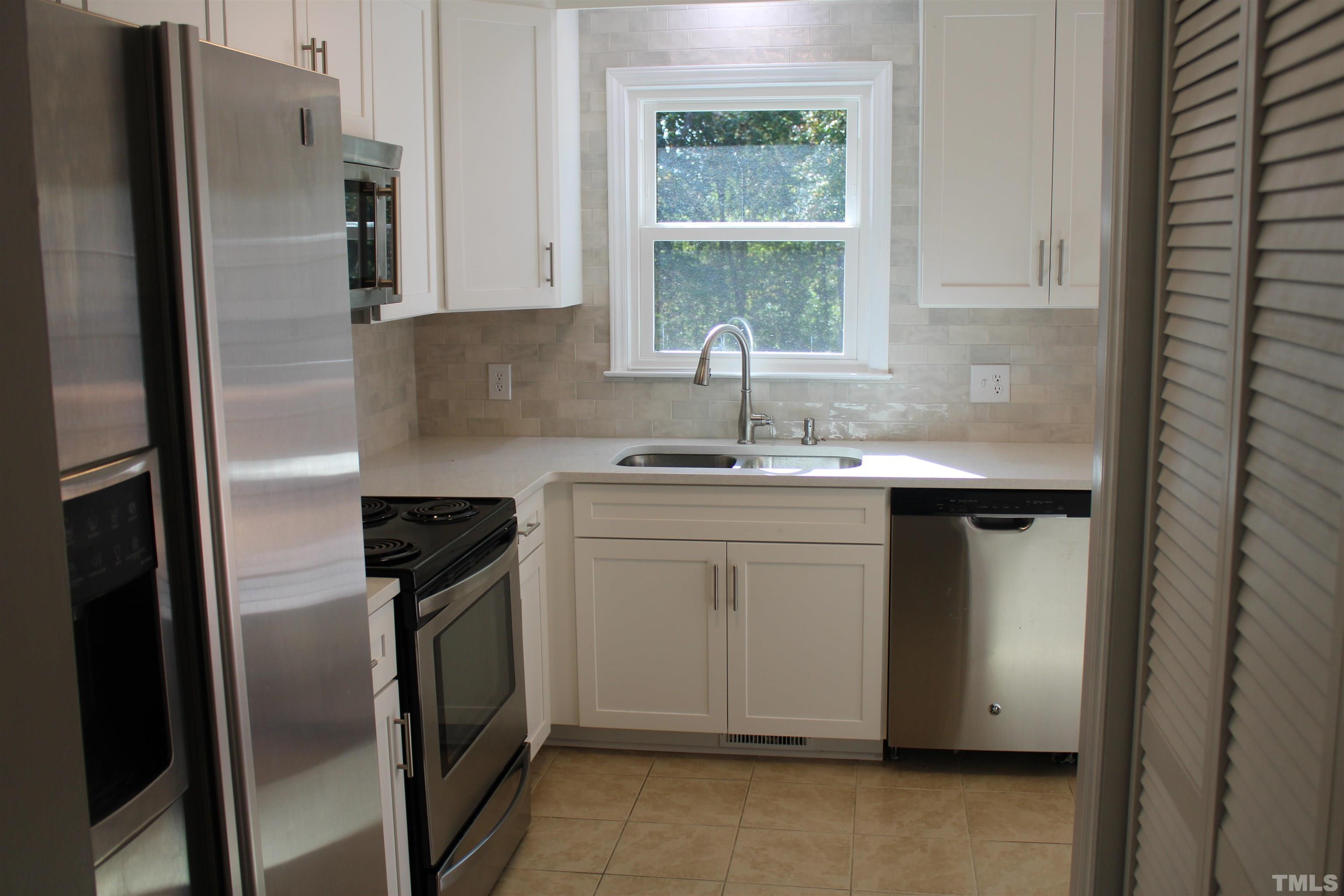 9300 Sauls Road Raleigh, NC 27603 - Photo 3 of 17 a kitchen with stainless steel appliances granite countertop a refrigerator sink and stove