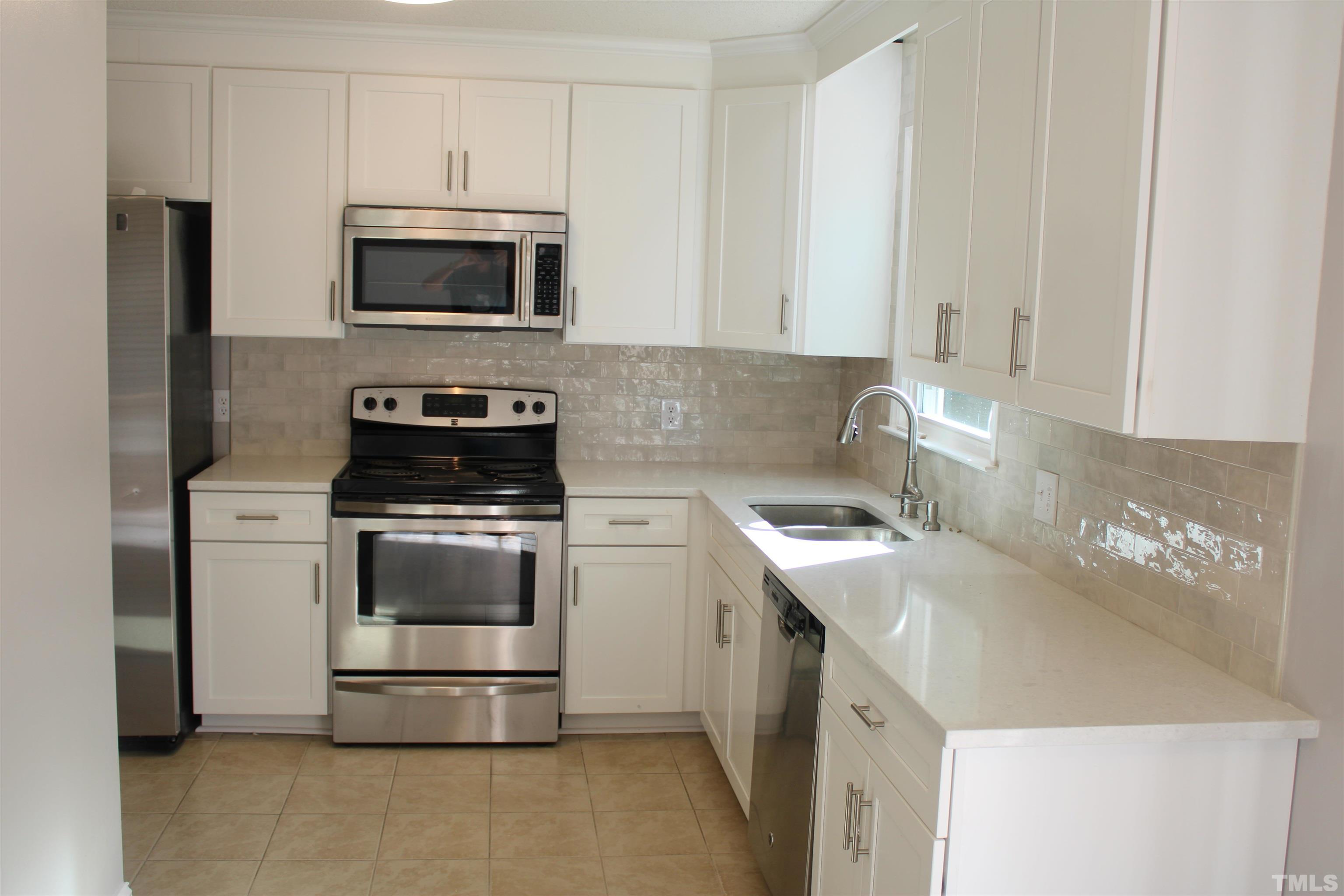 9300 Sauls Road Raleigh, NC 27603 - Photo 4 of 17 a kitchen with a stove and a microwave