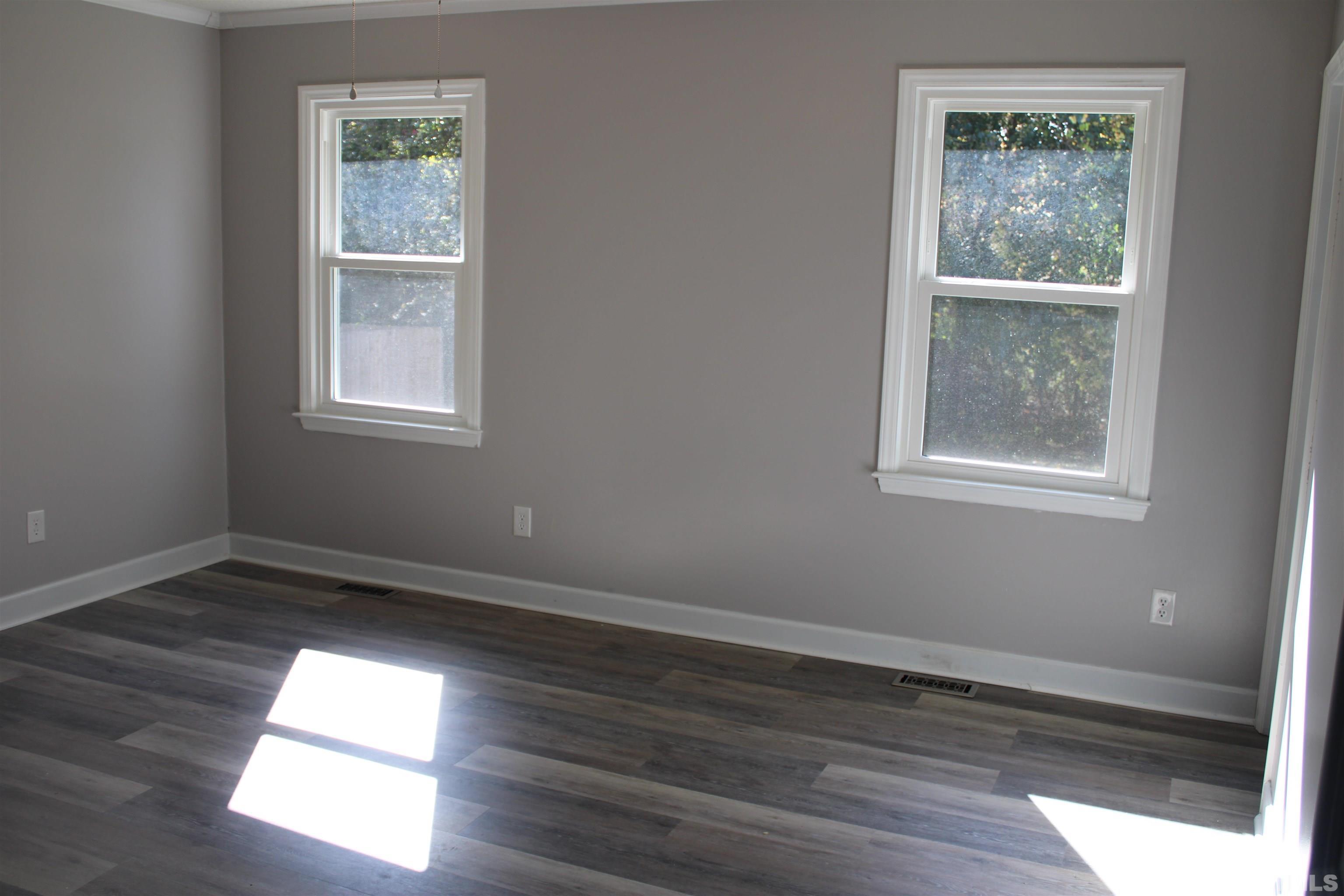 9300 Sauls Road Raleigh, NC 27603 - Photo 8 of 17 an empty room with wooden floor and windows