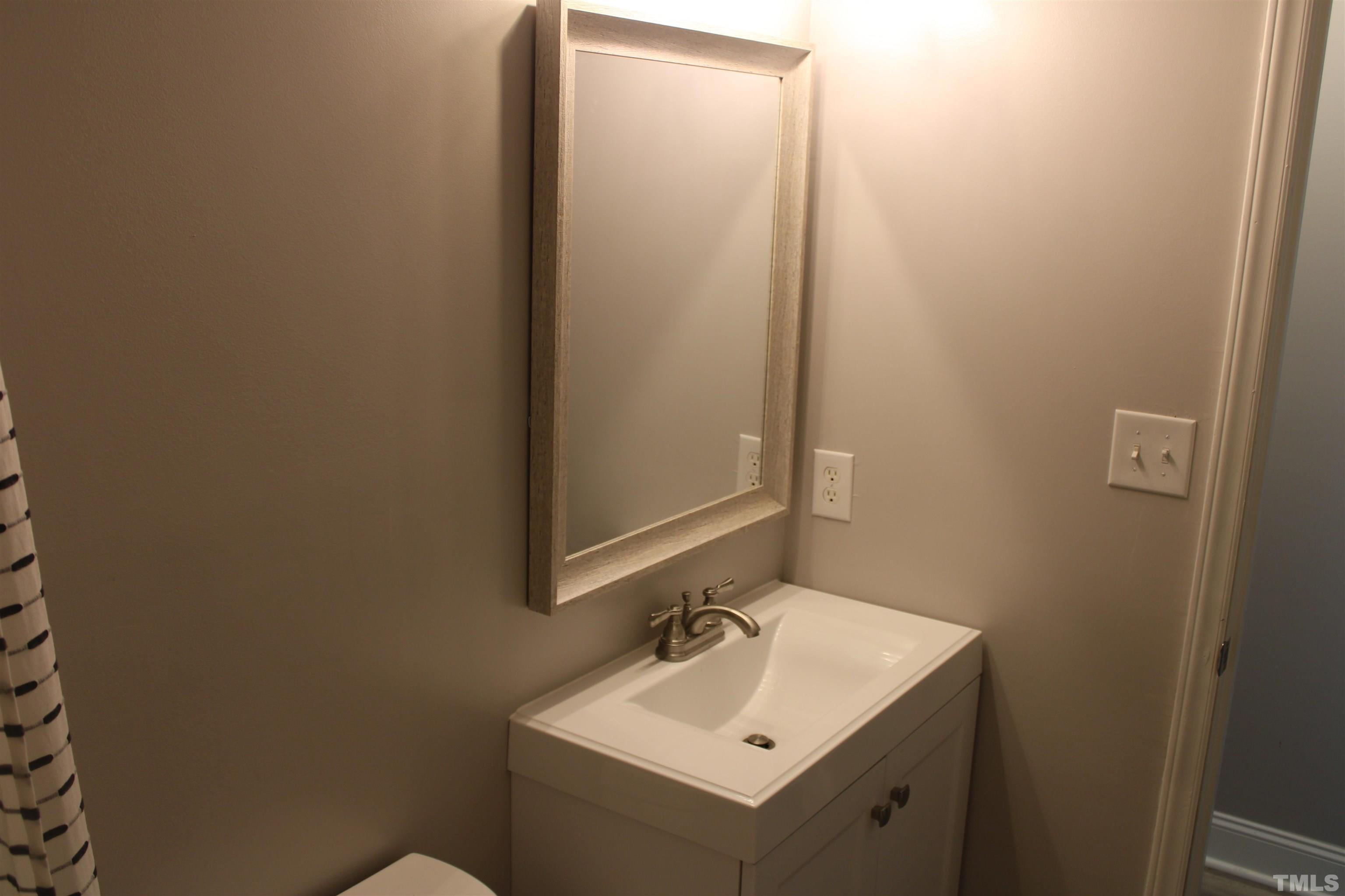 9300 Sauls Road Raleigh, NC 27603 - Photo 10 of 17 a bathroom with a sink and mirror with toilet