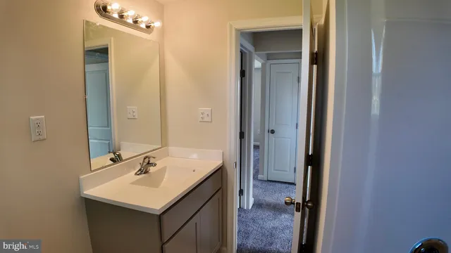 a bathroom with a sink mirror and a toilet