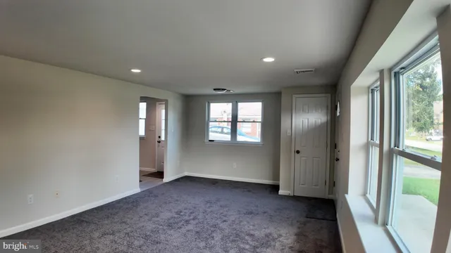 an empty room with windows and closet