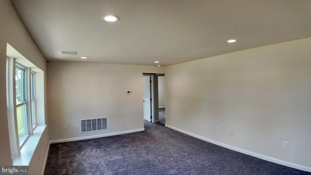 an empty room with a empty space and windows