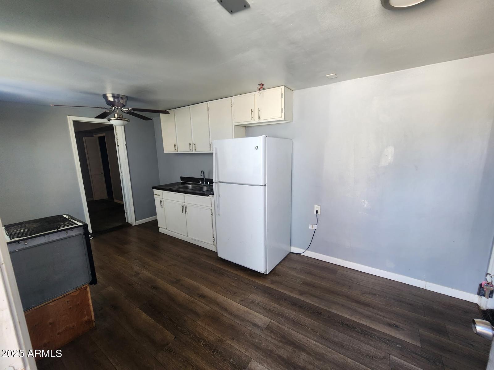 18835 North 25th Way Phoenix, AZ 85050 - Photo 7 of 9 a kitchen with a refrigerator a stove top oven a sink and wooden floor