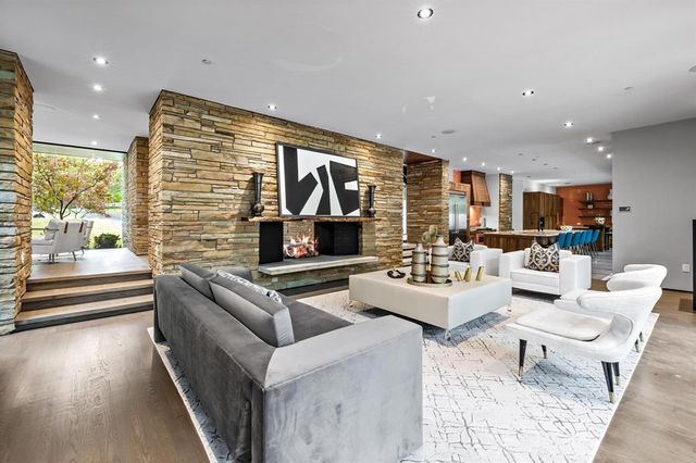 a living room with fireplace furniture and a large window