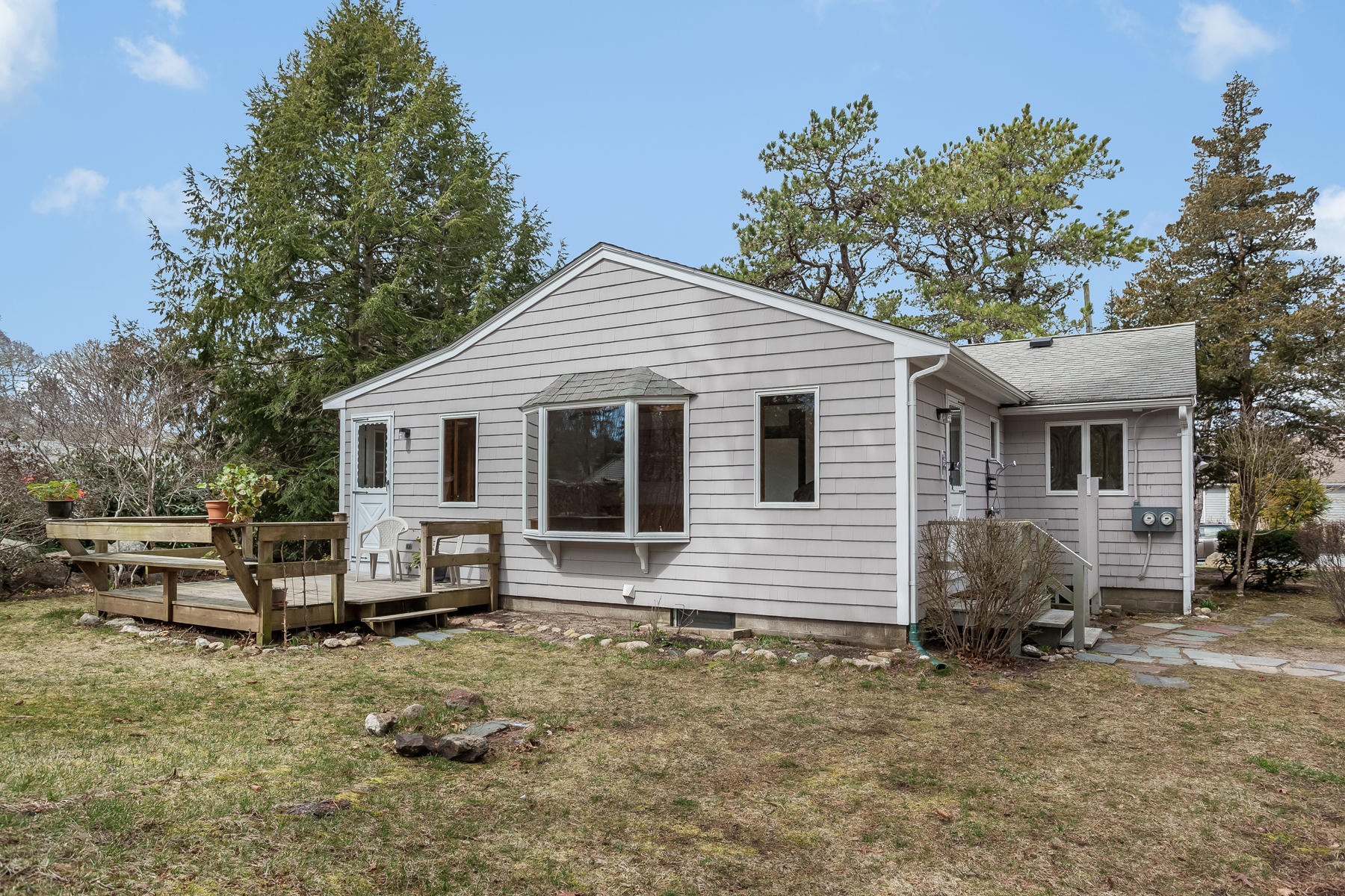 72 Eel Pond Road Bourne, MA 02532 - Photo 16 of 21 a view of a white house that has a small yard and large trees