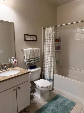 a bathroom with a granite countertop sink a toilet and shower