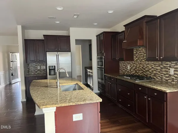 a kitchen with stainless steel appliances kitchen island granite countertop a kitchen island a cabinets and wooden floor
