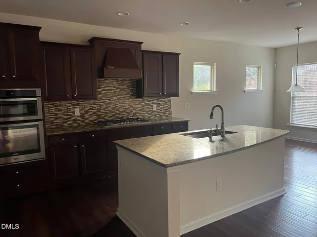 a kitchen with stainless steel appliances granite countertop a sink stove and cabinets