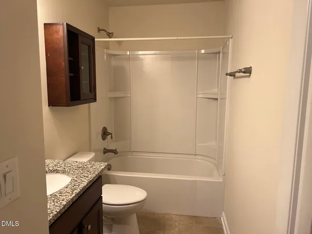 a bathroom with a granite countertop toilet sink and shower