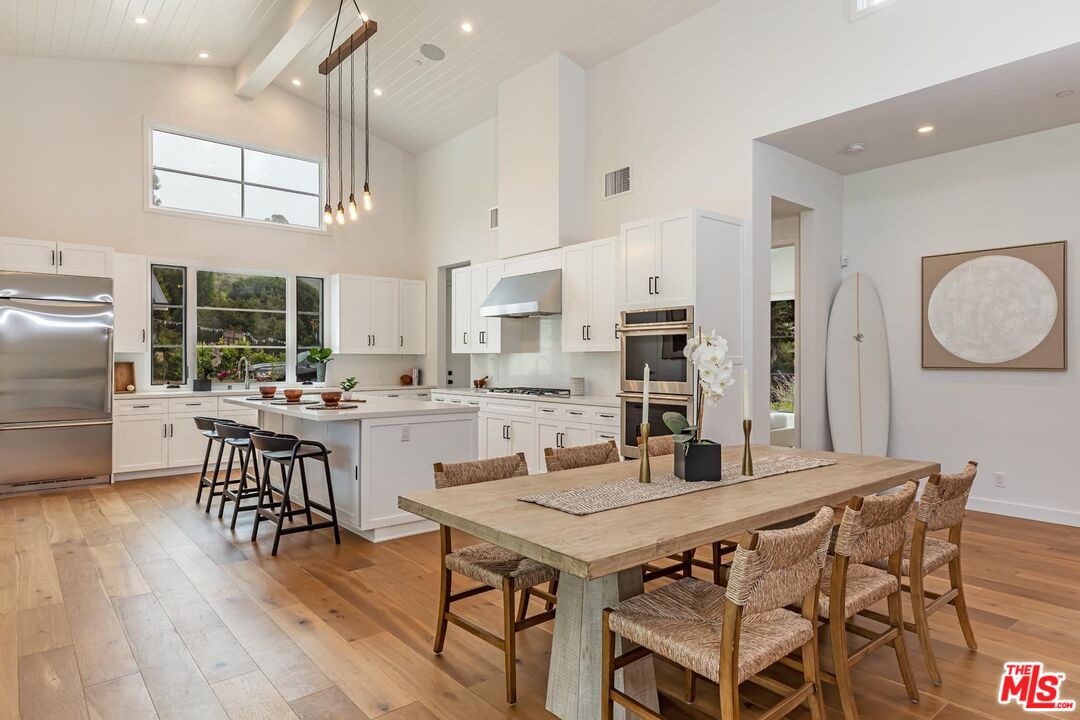 5916 Bonsall Drive Malibu, CA 90265 - Photo 6 of 20 a kitchen with a table chairs a sink dishwasher stove and cabinets with wooden floor
