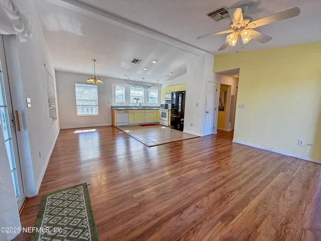 a view of a livingroom with wooden floor and a ceiling fan