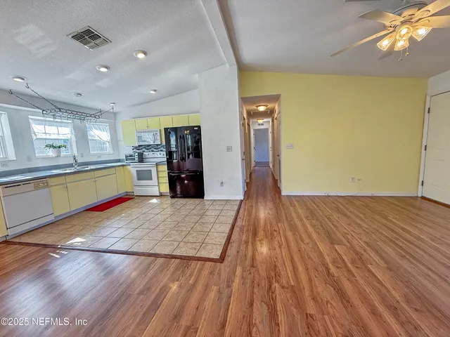 a kitchen with stainless steel appliances granite countertop a stove a refrigerator and a wooden floors