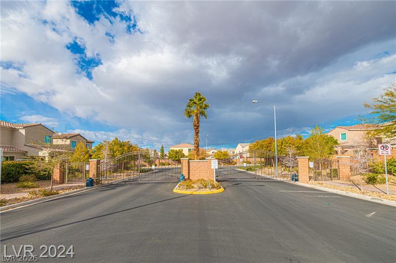 9056 Tony Ridge Avenue Las Vegas, NV 89148 - Photo 30 of 32 Secure community entrance with elegant gates and well-maintained landscaping beckons residents home.