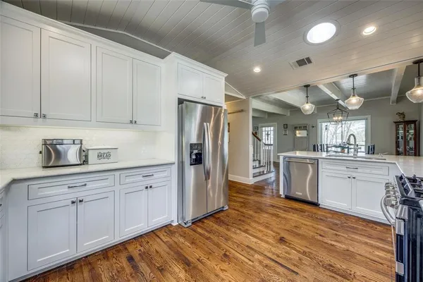 a kitchen with white cabinets and stainless steel appliances