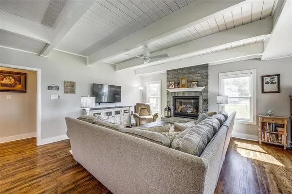 a living room with furniture a fireplace and a wooden floor