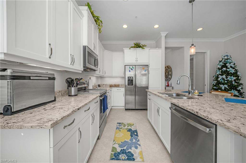 6552 Dominica Drive, Unit 101 Naples, FL 34113 - Photo 7 of 50 a kitchen with stainless steel appliances granite countertop a sink a stove and a refrigerator