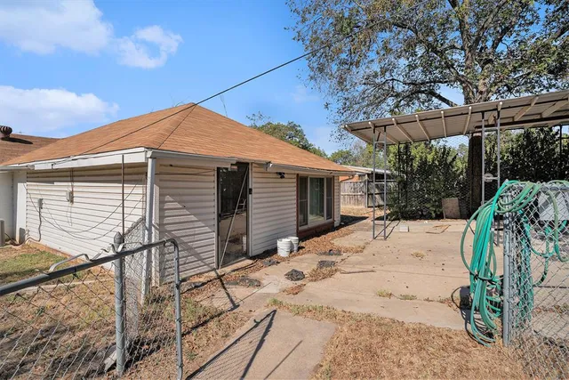 a backyard of a house with large trees and barbeque oven