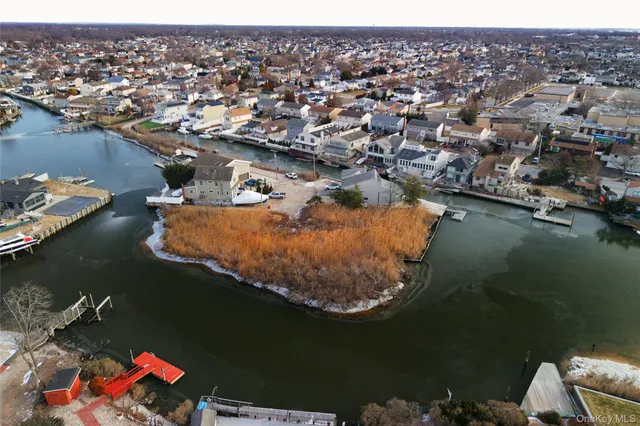 an aerial view of residential houses with outdoor space and lake view