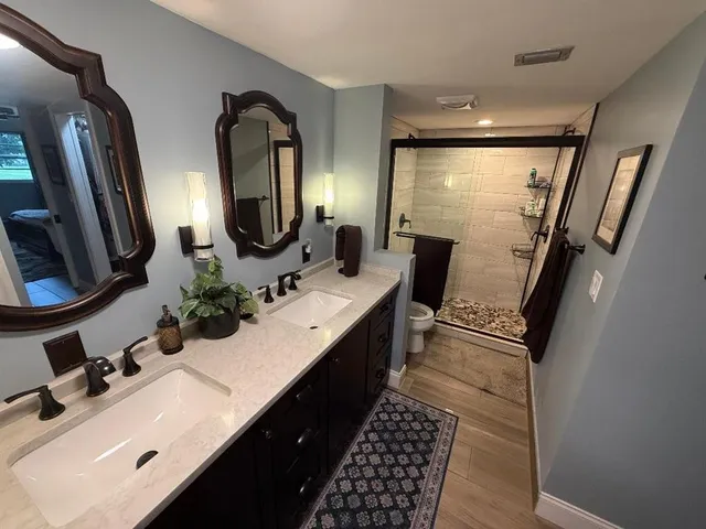 a bathroom with double vanity and a mirror