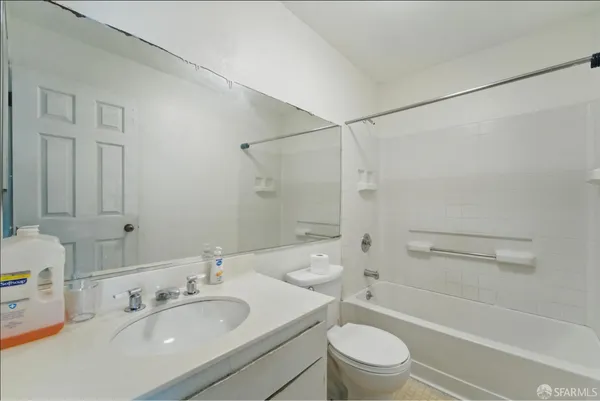 a bathroom with a sink a toilet and a large mirror