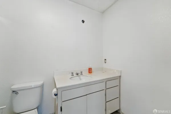 a utility room with a sink a toilet and vanity